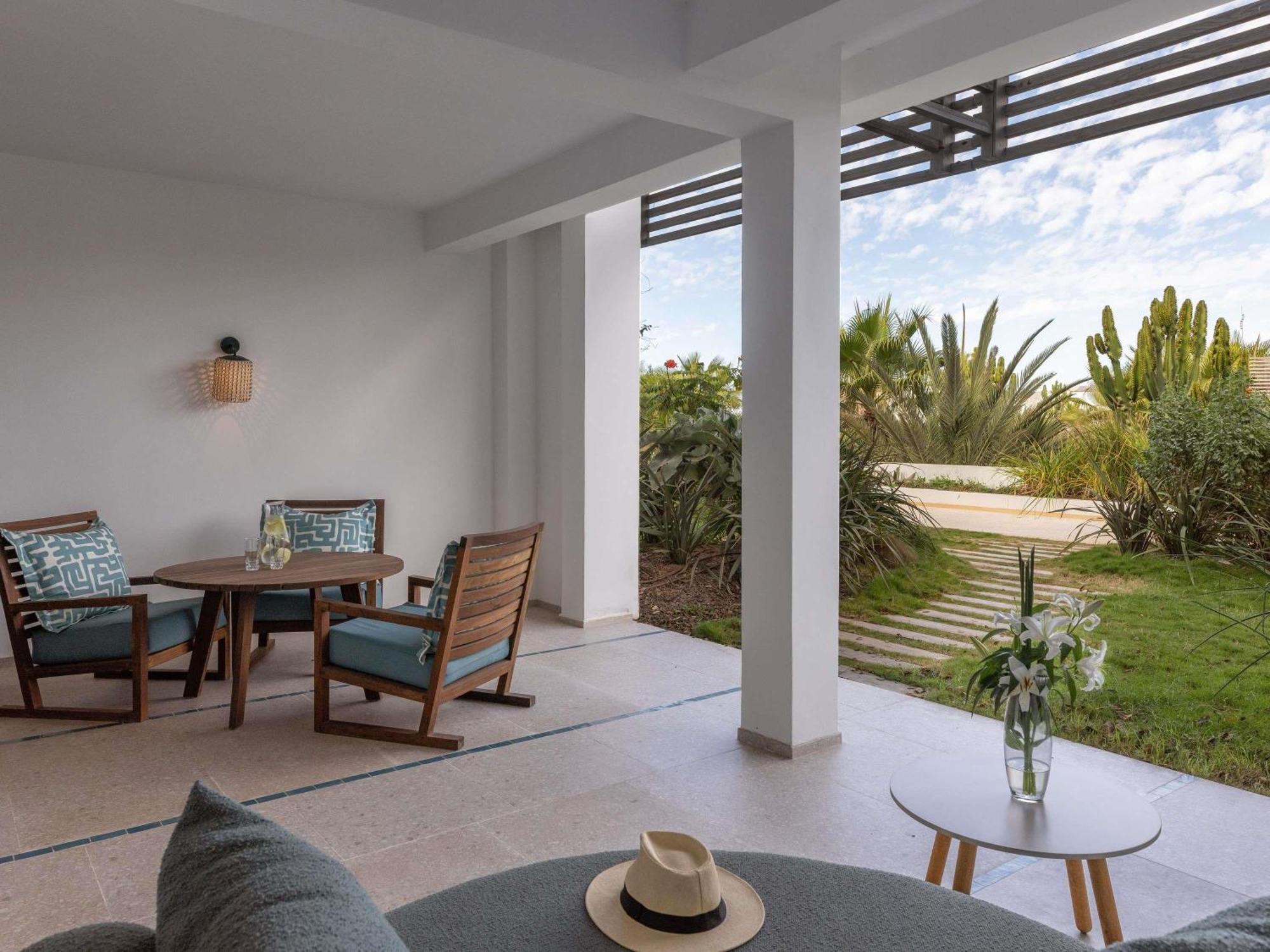 Junior-suite met kingsize bed, terras en uitzicht op het zwembad en zee