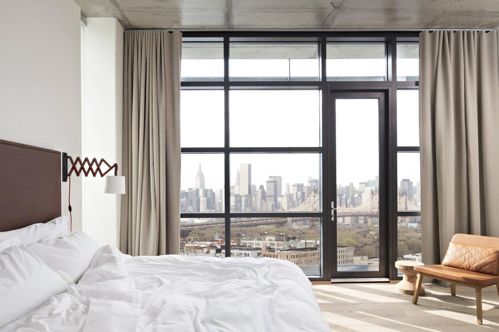 Habitación con cama extragrande y balcón con vistas a Manhattan